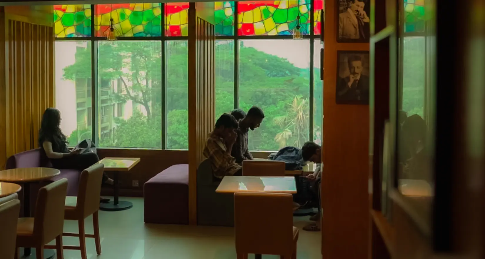 Guests spending time beside the large windows at Cafelytics