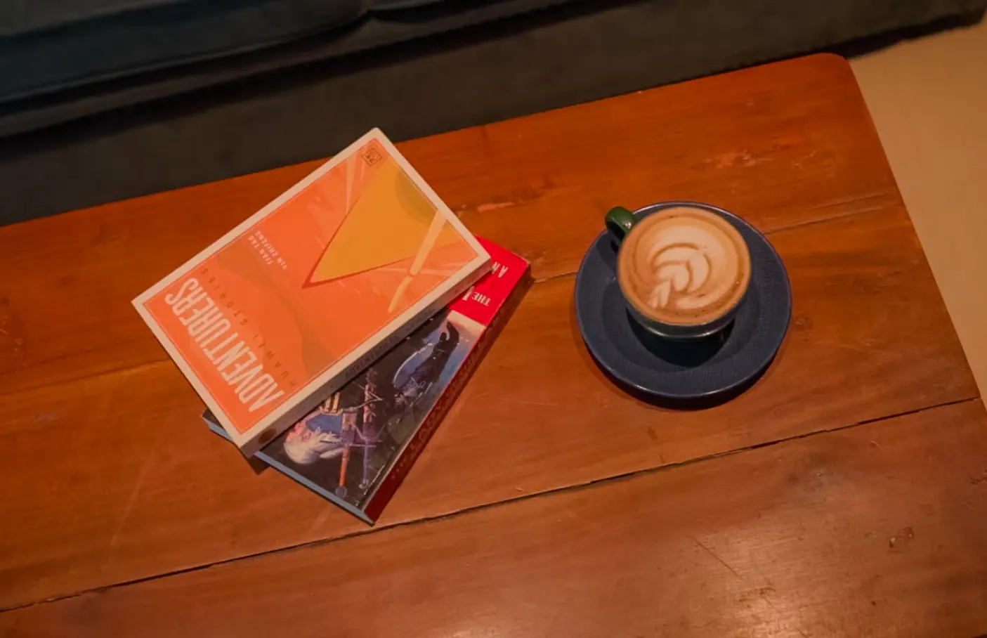 Cup of coffee and books on a wooden table at Cafelytics